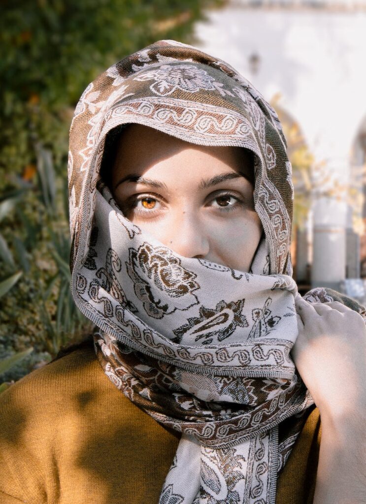 close up photo of a woman wearing brown and beige headscarf